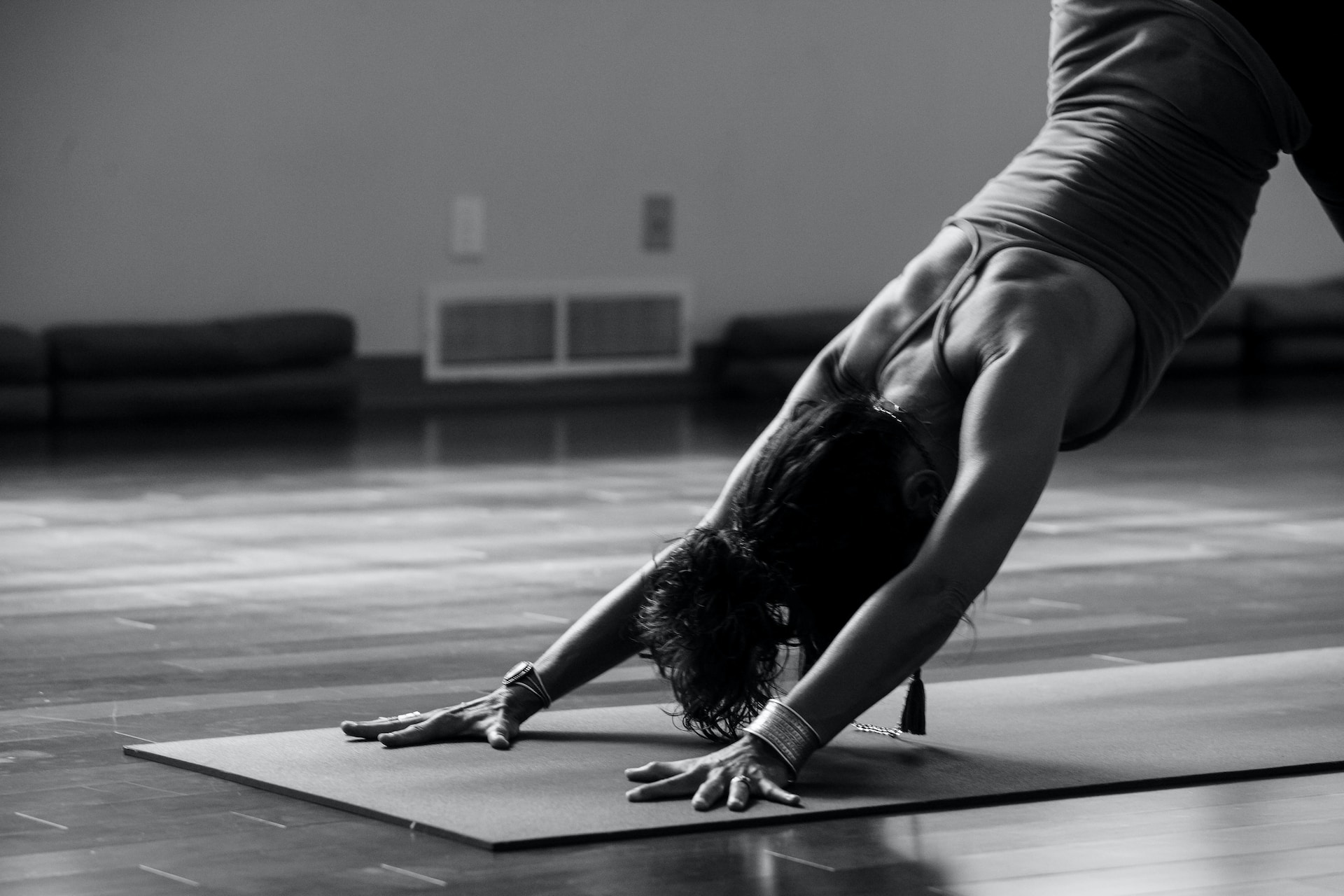 Une pratiquante de yoga en débardeur fait une position tête en bas.