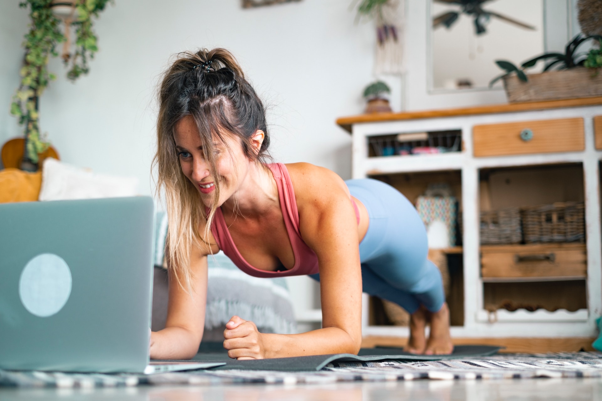 Une femme sportive en position de planche devant un ordinateur.