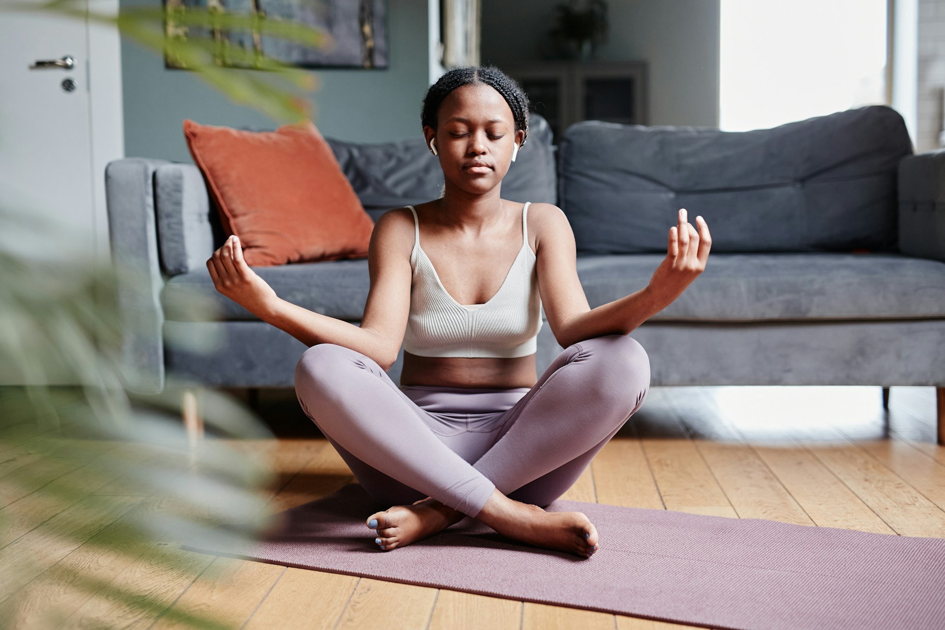 Une pratiquante se relaxe avec une posture de yoga chez elle.
