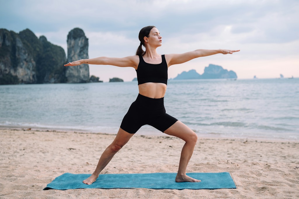 Une dame fait de yoga à la mer.