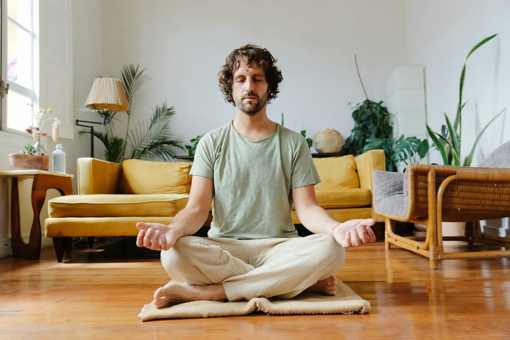 Un garçon photographié de face, lors d'une séance de méditation à domicile.