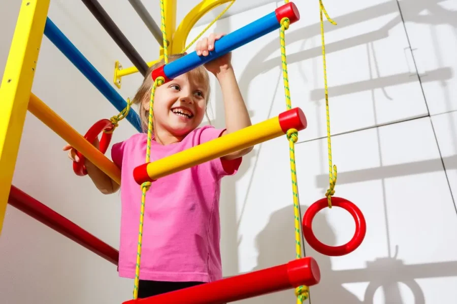 Une petite fille s'amuse avec des barreaux d'échelle pour enfant.