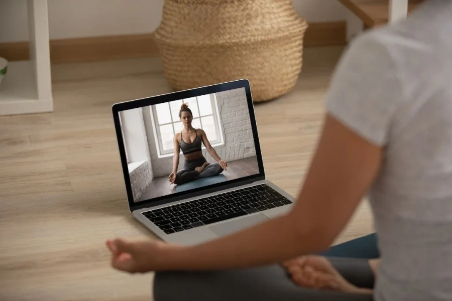 Une adulte prend un cours de yoga par internet.