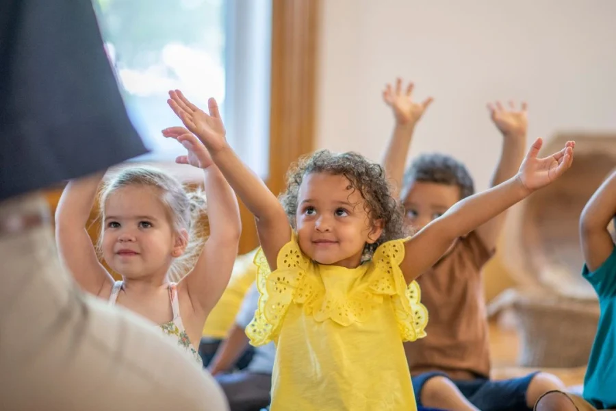 Un adulte lors d'un cours de yoga pour enfants.