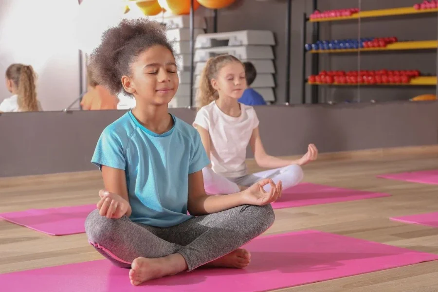 Deux enfants photographiés en pleine posture de yoga.