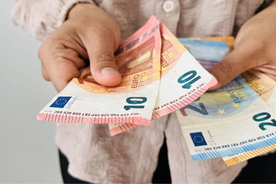 Un adulte fait un paiement en euros en espèces.