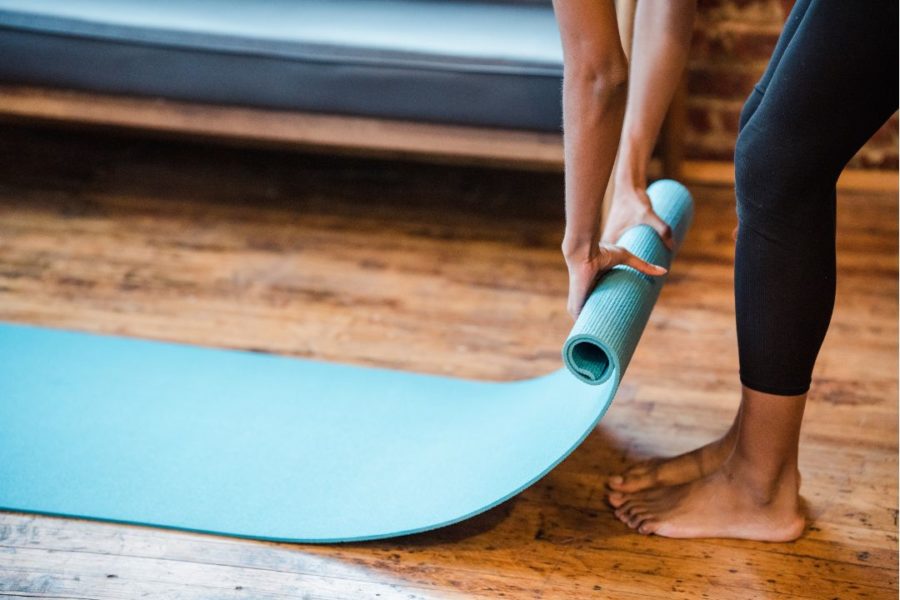 Un pratiquante de yoga enroule un tapis à la fin d'une séance.