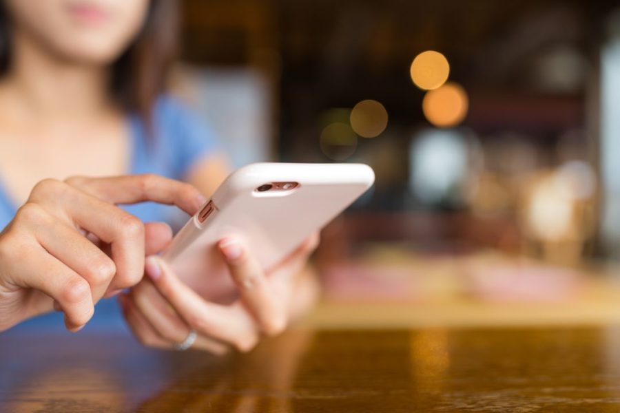 Mains d'une femme naviguant sur une application mobile.